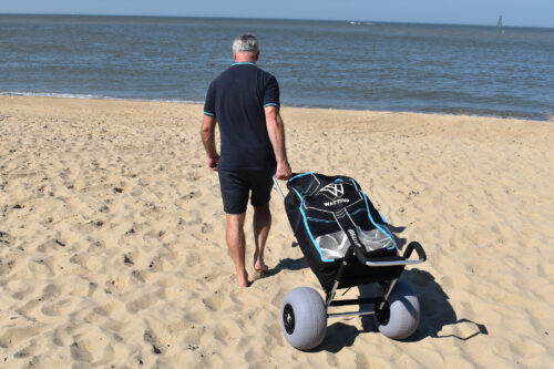carro con ruedas para arena multipropósito siendo arrastrado por hombre en playa