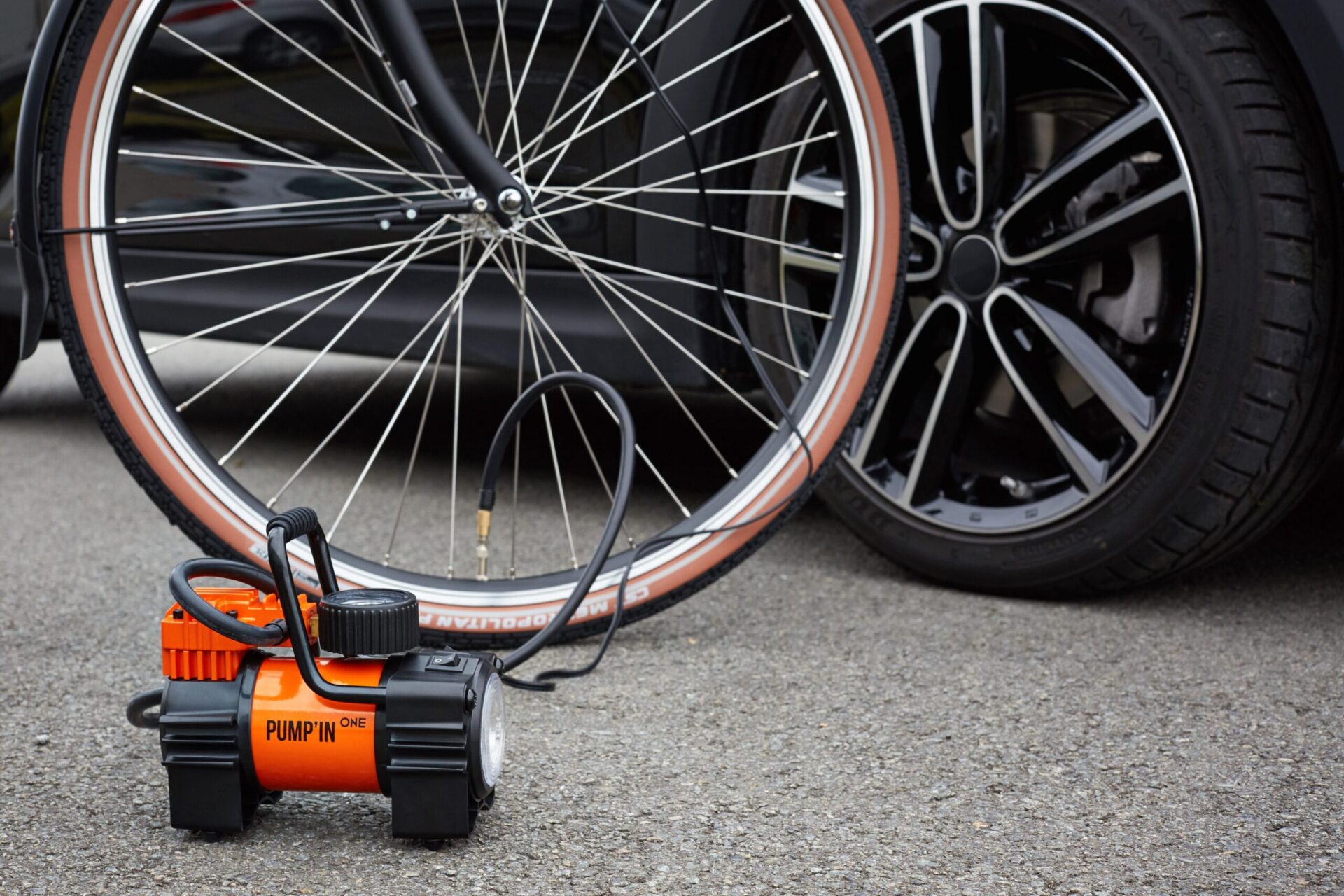 One_velo compresor pequeño de aire negro y naranja dado aire a la rueda de una bici