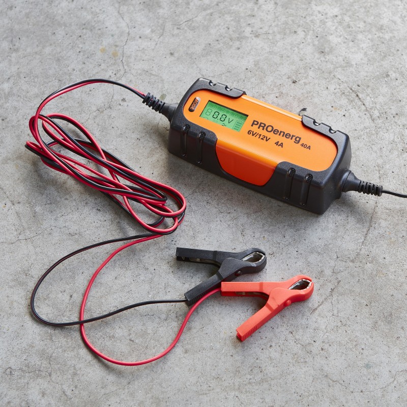 proenerg-100 cargador de batería negro y naranja con pinzas